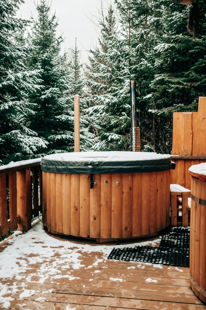 Open-air bath interior near forest, winter, snow view. Wooden hot tub outside